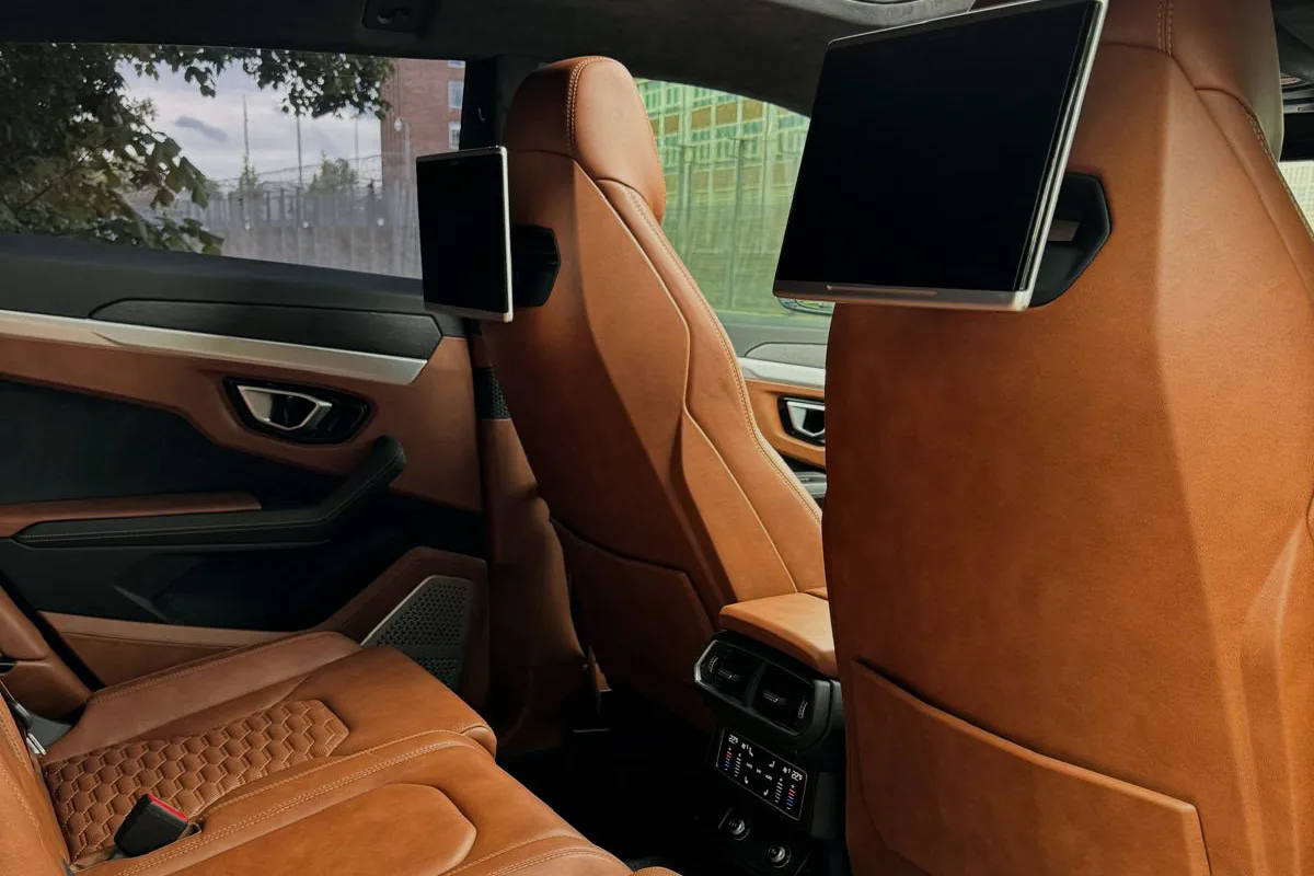 Tan leather rear cabin of the chauffeur-driven Lamborghini Urus wedding car