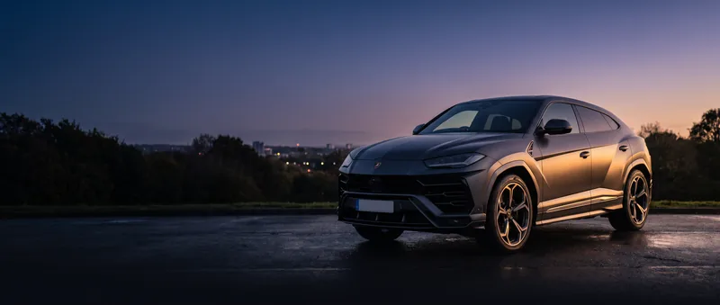The grey Urus side-on at dusk