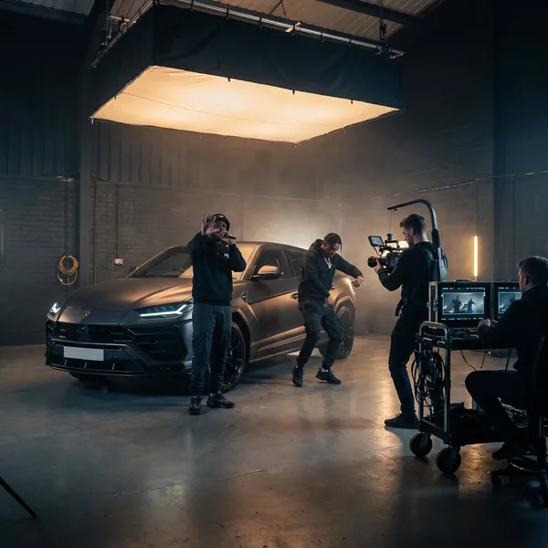 Artists performing in front of the Lamborghini Urus on a music video set
